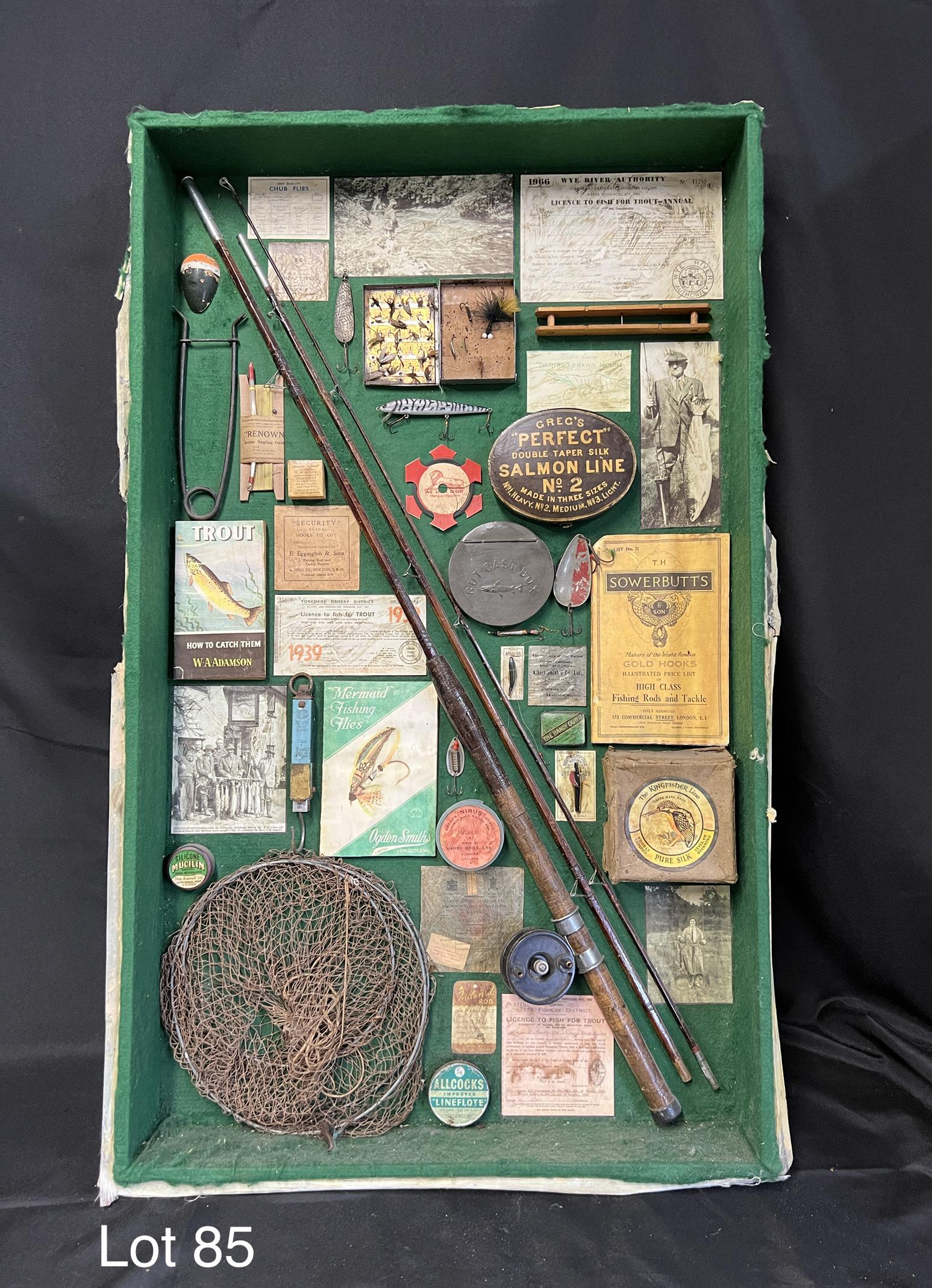 Vintage English Fishing Accessory Display: A collection of vintage English fishing items presented in a wooden shadow box. Items include pure silk Kingfisher Line, "Mermaid" Fishing Flies by Ogden Smith, a vintage wooden rod, fishing net and m
