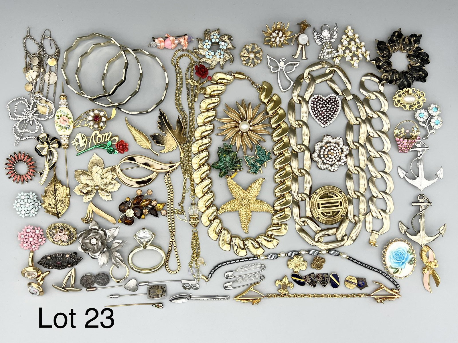 Collection of Gold Toned Costume Jewelry: A nice lot of gold toned costume jewelry including lots of necklaces, brooches, stick pins, bracelets and more. Of note is a chunky link chain necklace and bracelet set and a starfish brooch.
