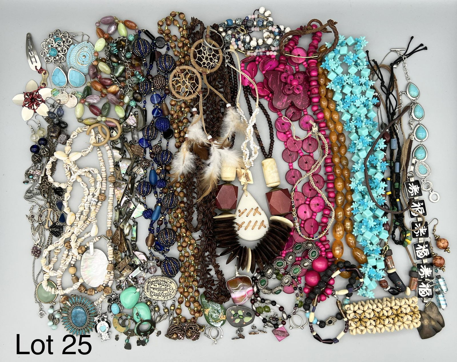 Bohemian Style Costume Lot: Collection of costume jewelry with a focus on bohemian style. Includes several beaded necklaces, a pair of dream catcher keychains, a multicolored stone pendant wrapped in wire and much more.