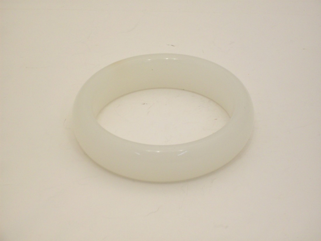 White Jade or Jade-like Material Bangle: China. 3 1/4" X 3/4" White Jade or Jade-like Material with a touch of russet, excellent condition