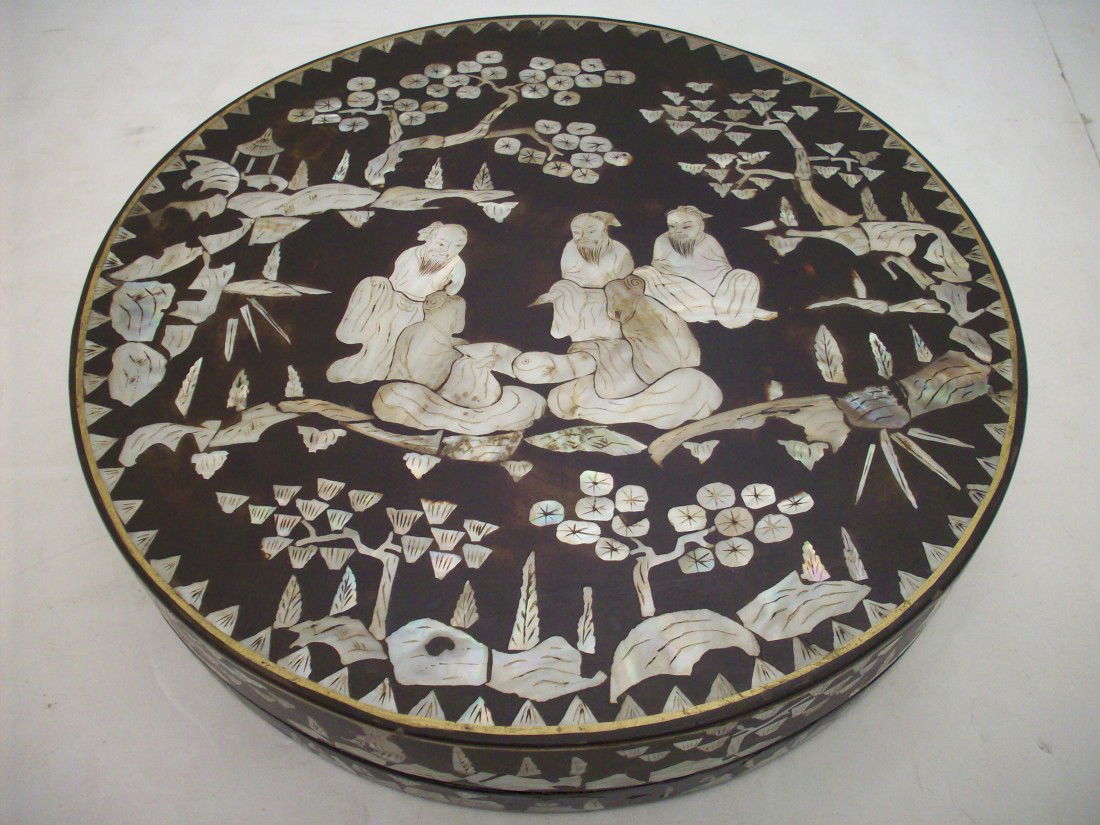 Mother of Pearl Round Box With Sectional Server: 12 3/4" X 2 3/8" round box, heavily inlaid oriental scenes on the top and sides, lacquered wood nine piece sectional server, interior of box also lacquered with some cracks, MOP appears to be all inta