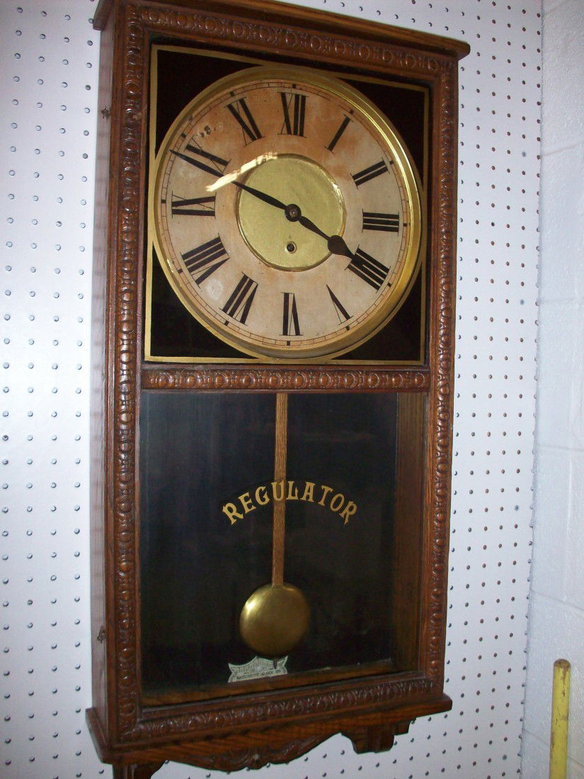 Waterbury Oak Wall Regulator Clock: 34" X 16" X 4 3/4", time only, circa late 19th century, loss on face, double latch front door with painted glass, with key and pendulum, working condition