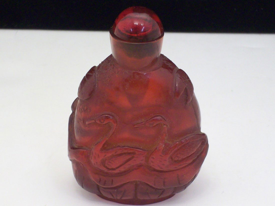 Carved Red Amber Bottle: 2 1/4" Craved red Amber or a Amber-like Material in a bottle shape, will only hold small amount, with a red topped stopper