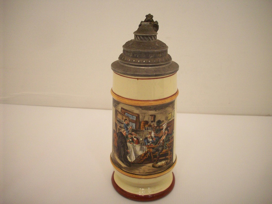 Vintage German Beer Stein: 10 3/4" tall. Lidded beer stein, German wring on pewter lid, picture of people drinking and smoking, marked but unable to read, excellent condition