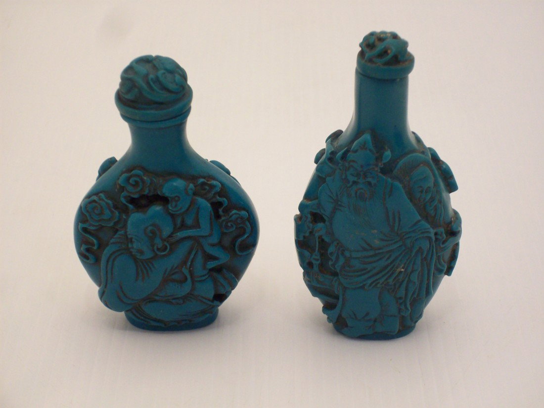 Carved Soapstone Snuff Bottles: China, Lot of two green soapstone snuff bottles, one is 2 7/8" and the other is 3 1/4", taller one has carvings of a gnarled pine and a warrior in relief. The other one has carvings of Buddha with chi