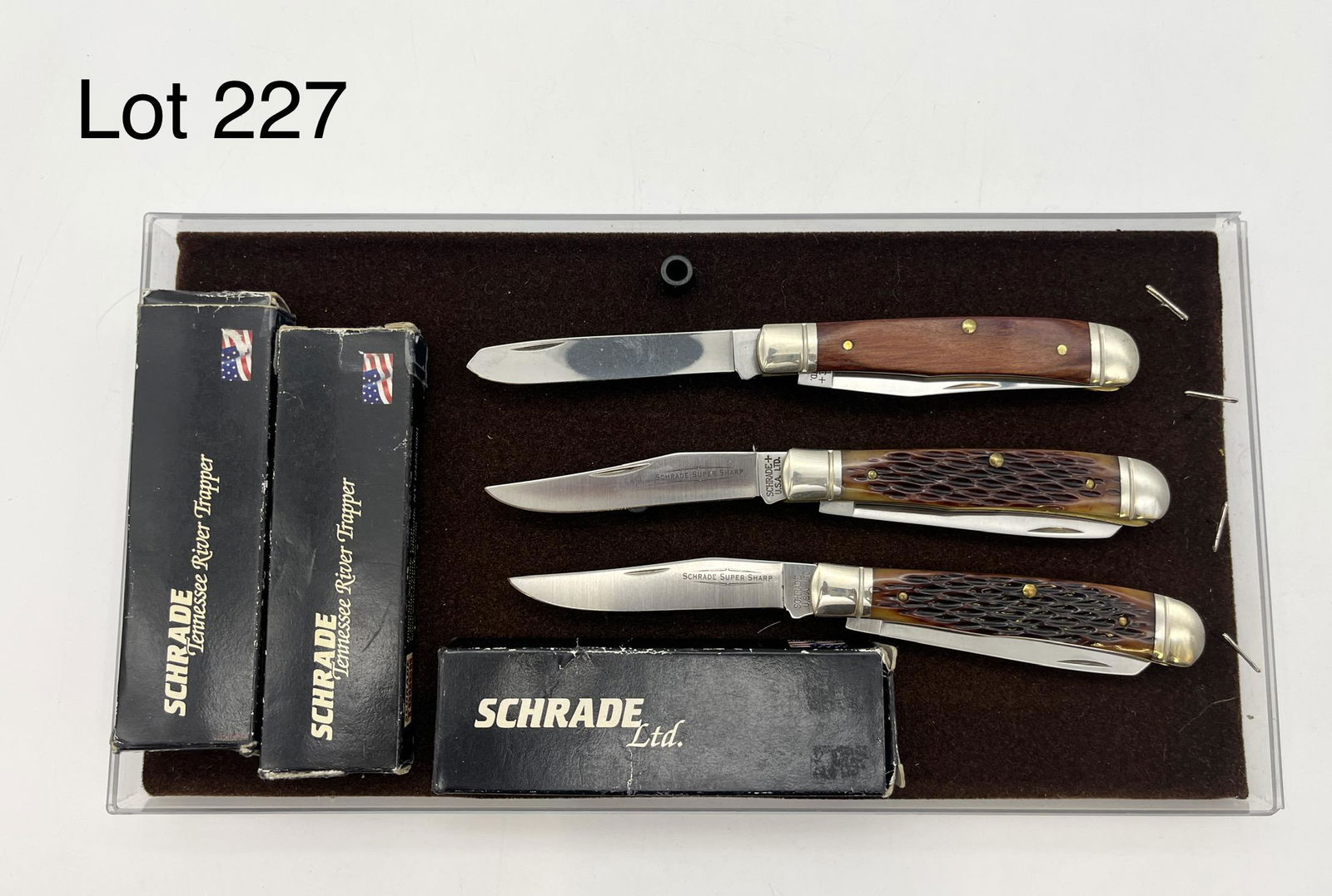Trio of Near Mint Schrade Pocket Knives: A trio of folding pocket knives by Schrade, all in near mint condition. Two knives are TRT96 Tennessee River Trapper models with brown jigged bone handles, with blade reading "Schrade Super Sharp". Th