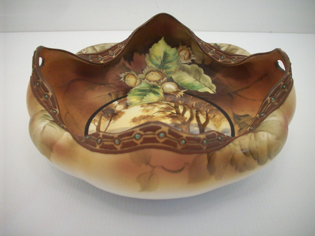 Hand Painted Nippon Bowl: 3 7/8 X 9 1/2"wide, Porcelain bowl handpainted, interior has a round center panel of a lake scene surrounded by a fall colored background with leaves and seeds, exterior has terra cotta and green patt