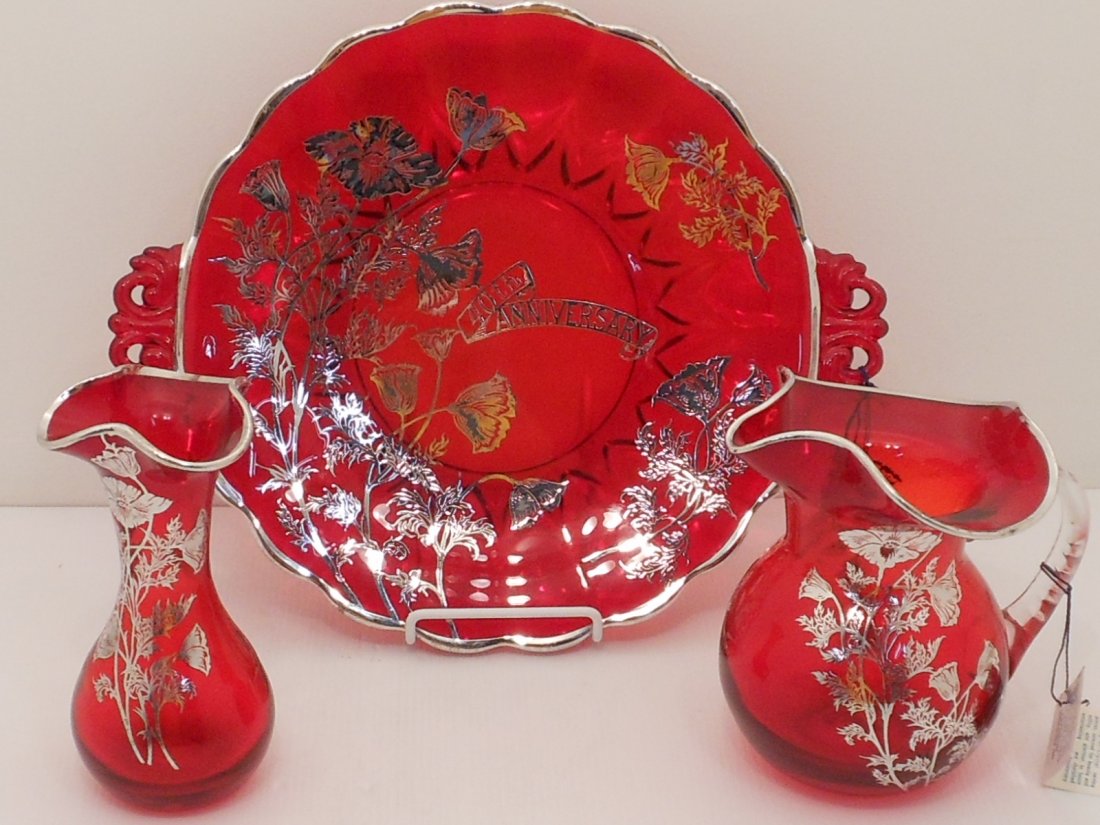 Sterling on Cranberry Crystal Set: 13 1/2" cranberry serving plate with Rhodium-finished Sterling decorations, 40th Anniversary plate. Small pitcher and flower vase have same Sterling decorations and pattern. Made by Silver City Glass 