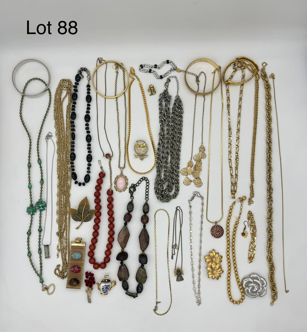 Signed Costume Jewelry Selection: A lot of signed costume jewelry with many in gold tones. Includes pieces from Monet, Napier, Sarah Coventry, Moonbabies, Trifari, Loft, 1928, Chaps, and more.