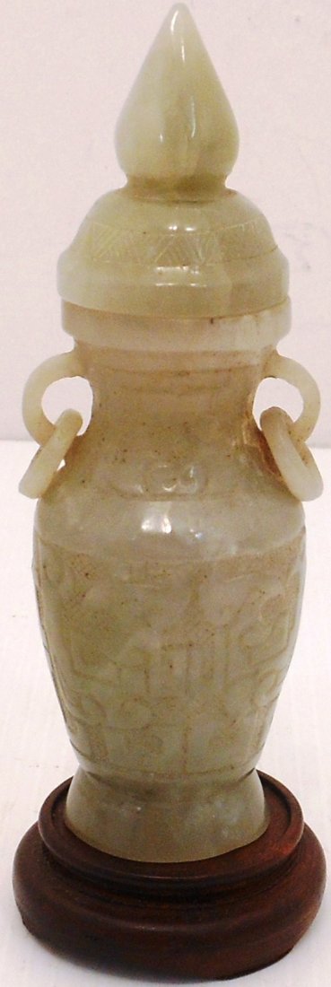 Jade Lidded Vase with Stand: China, 4 1/2" tall X 11/2" wide, carved gray green lidded vase decorated with stylized Foo Dogs and patterned designs, loop handles with rings, wood stand, great condition