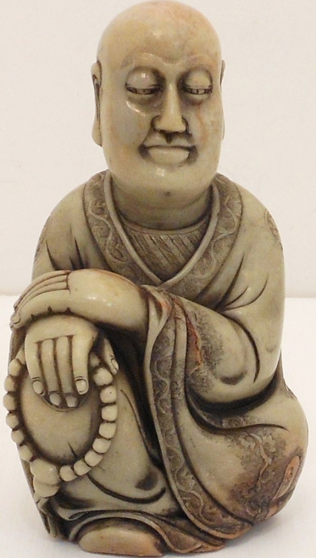 19th Century Carved Soapstone Buddha: China, 6 3/4" tall X 4" wide X 3" deep, greenish soapstone carved Buddha sitting with right knee up, right hands is holding prayer beads and is resting on knee, left hand is resting on the right hand,