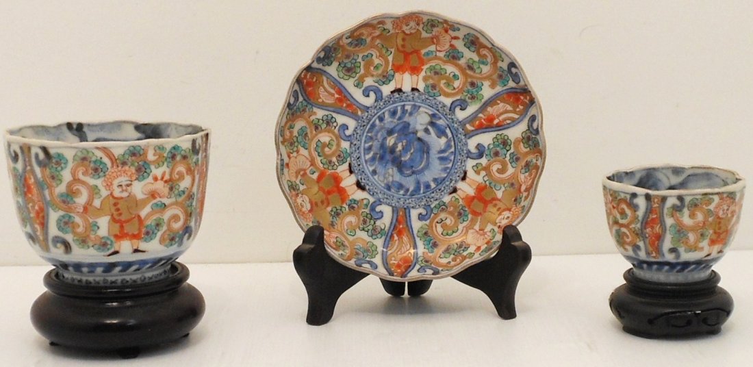 Famille Rose Porcelain Tea Cup Set: China, Lot of three. 2 1/2" X 3 1/4" Large paneled cup. 1 3/4" X 2 1/4" cup. 4 3/4" Saucepan. All are decorated the same, cups have interior decorations. All are unmarked, great condition with wood st