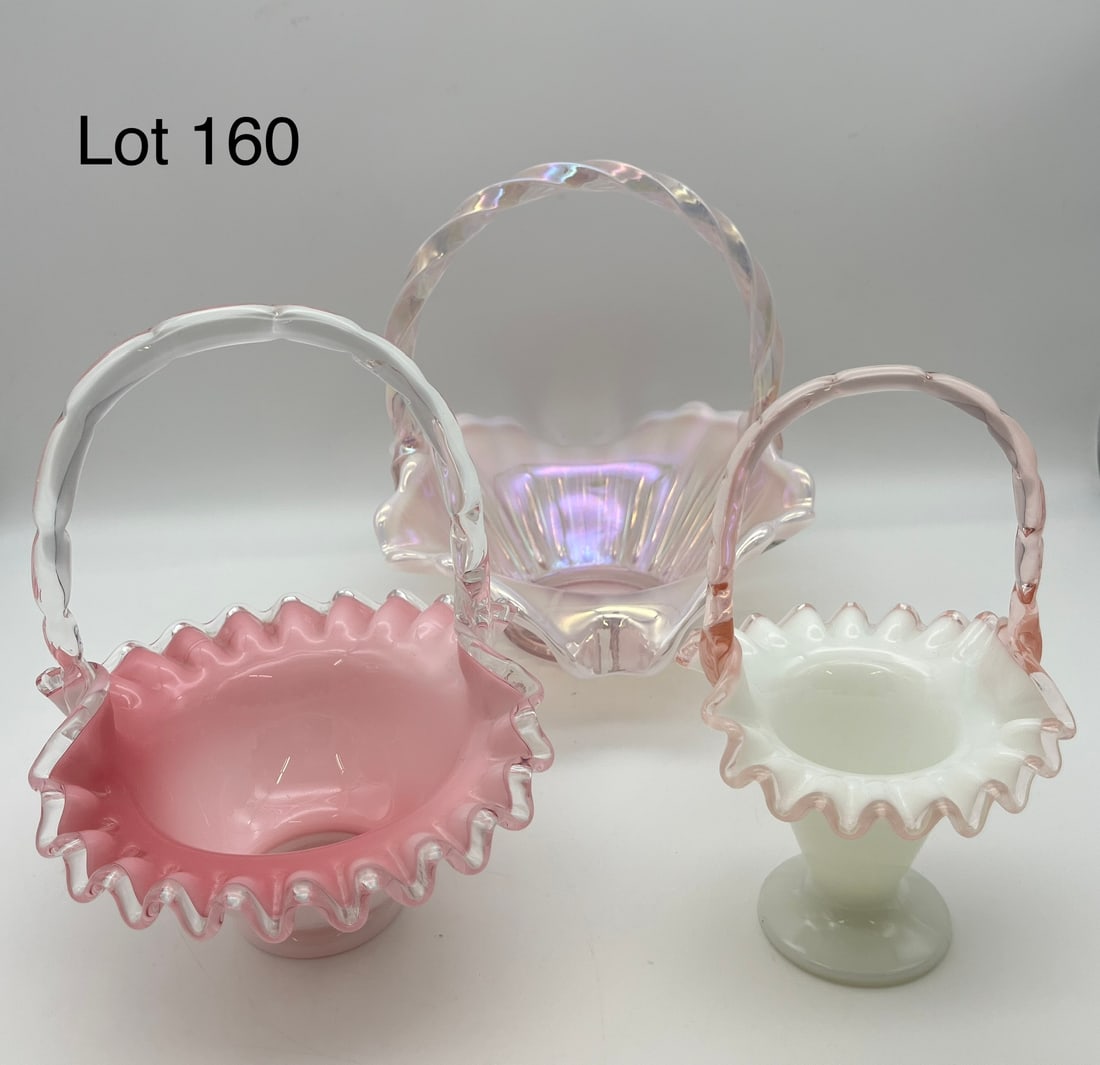Trio of Fenton Art Glass Decorative Baskets: A trio of Fenton art glass baskets in various shapes and sizes. From smallest to largest, lot includes: a thin opalescent glass basket, a white glass basket with pink interior, and a pink iridescent b