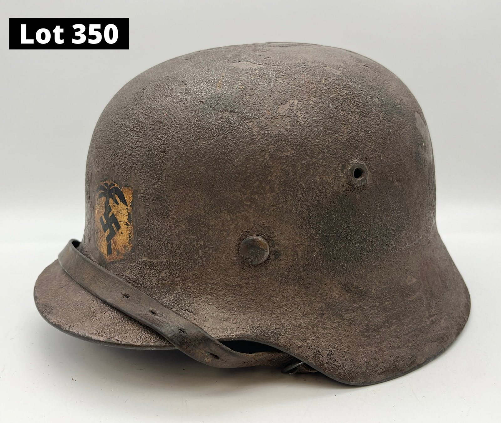 WWII Nazi Germany Afrika Korps Stahlhelm: A WWII Nazi Germany Afrika Korps stahlhelm helmet. Korps decal at the front of the helmet, leather interior and strap. Measures 11" x 9 1/4" x 6 1/2" *note - patina