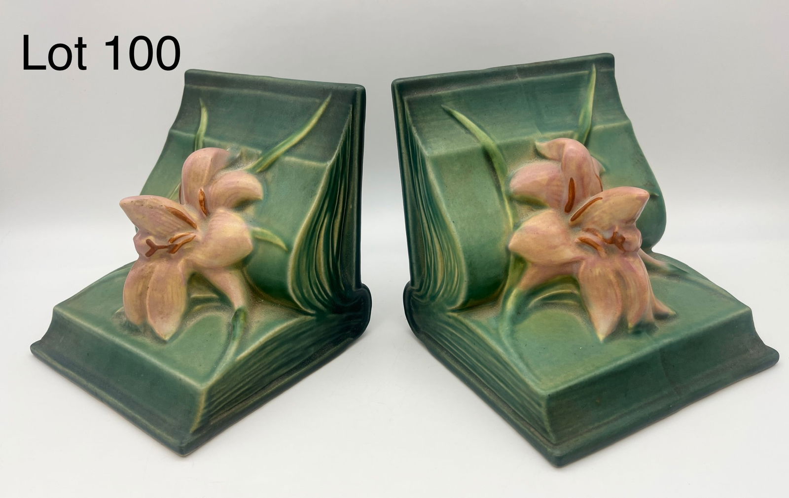 Pair of Roseville Zephyr Lily Bookends: A pair of Roseville green Zephyr Lily bookends, numbered 16 with makers mark at base. Very good condition, each measures 5 1/4" x 5 1/4" x 5" *note - no chips/cracks noted