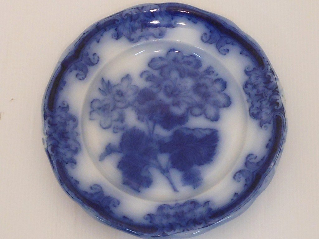 Wedgwood Royal Semi Porcelain Flow Blue Plate: 10 1/4" diameter, marked Wedgwood England flow blue plate in the geranium pattern, used condition with scratches, no chips or cracks, numerous glaze pops and manufacture defects, heavy crazing