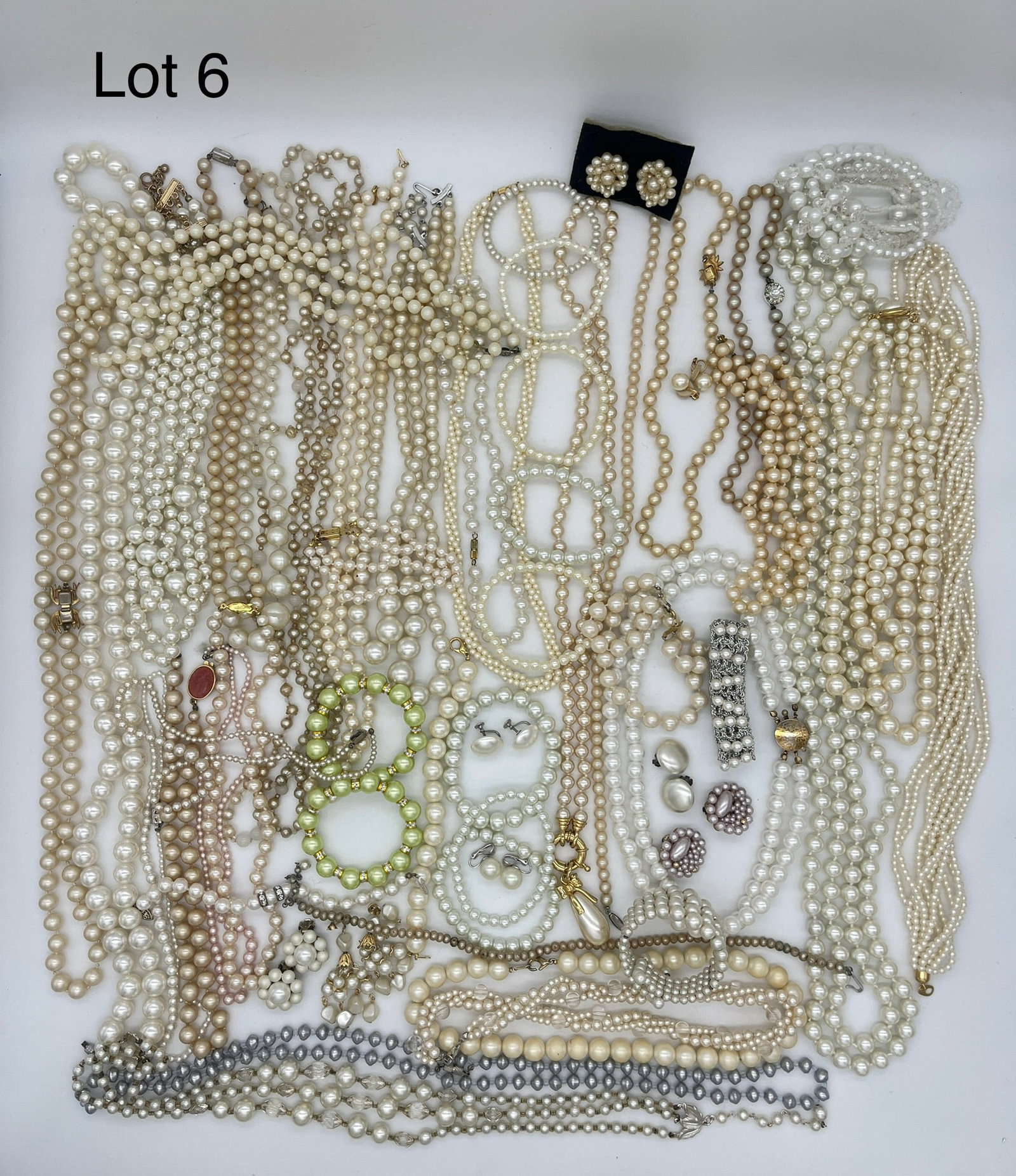 Elegant Lot of Costume Jewelry Featuring Faux Pearls: A lot of elegant costume jewelry necklaces, bracelets, and earrings in various shades of faux pearls. Some beaded necklaces are very long, with others including gold accents or stones.