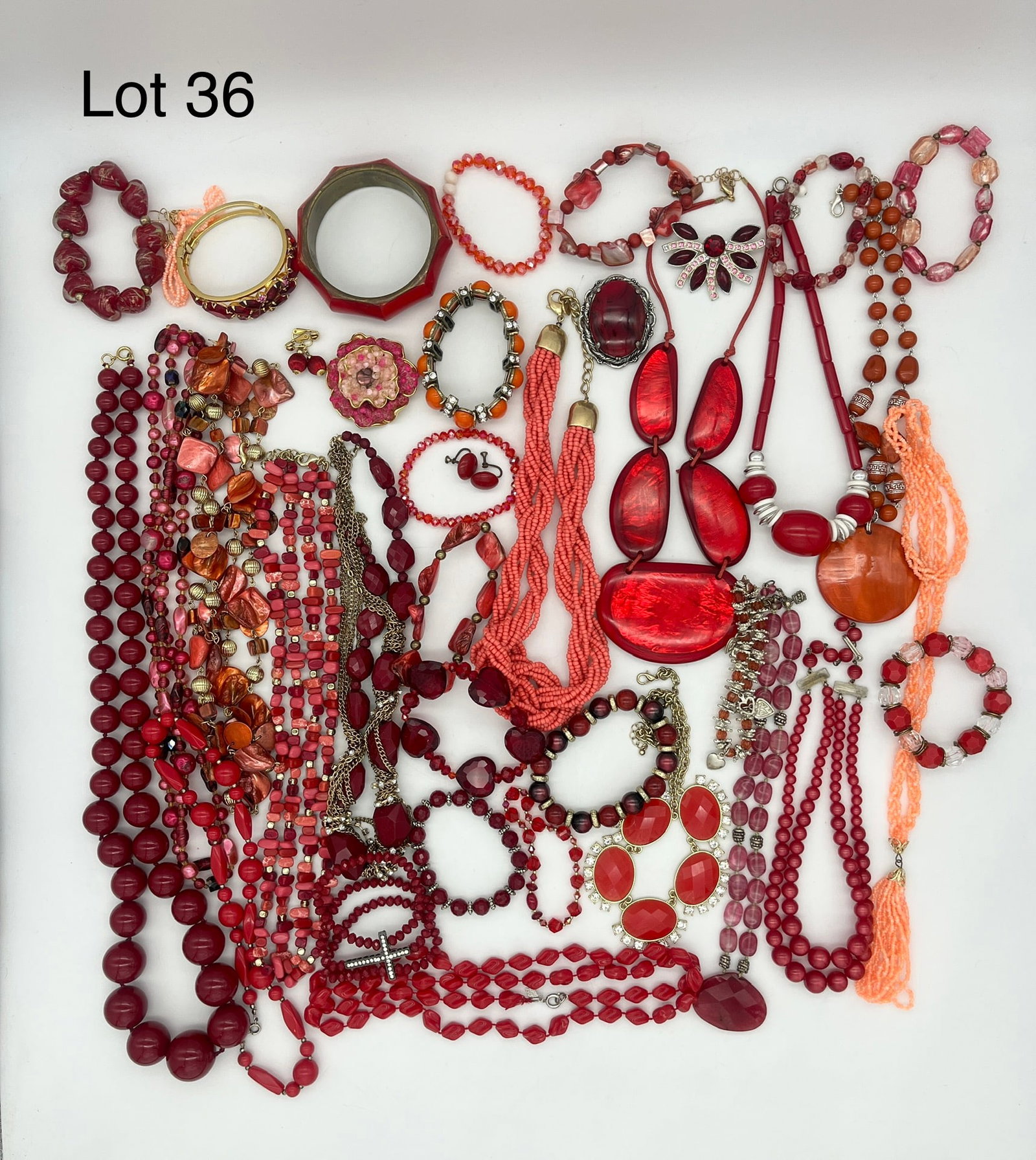Striking Mix of Red Tone Costume Jewelry: A mix of striking costume jewelry including beads, resin, and faux stones in bright red tones. Lot shows necklaces, bracelets, pins, and earrings.