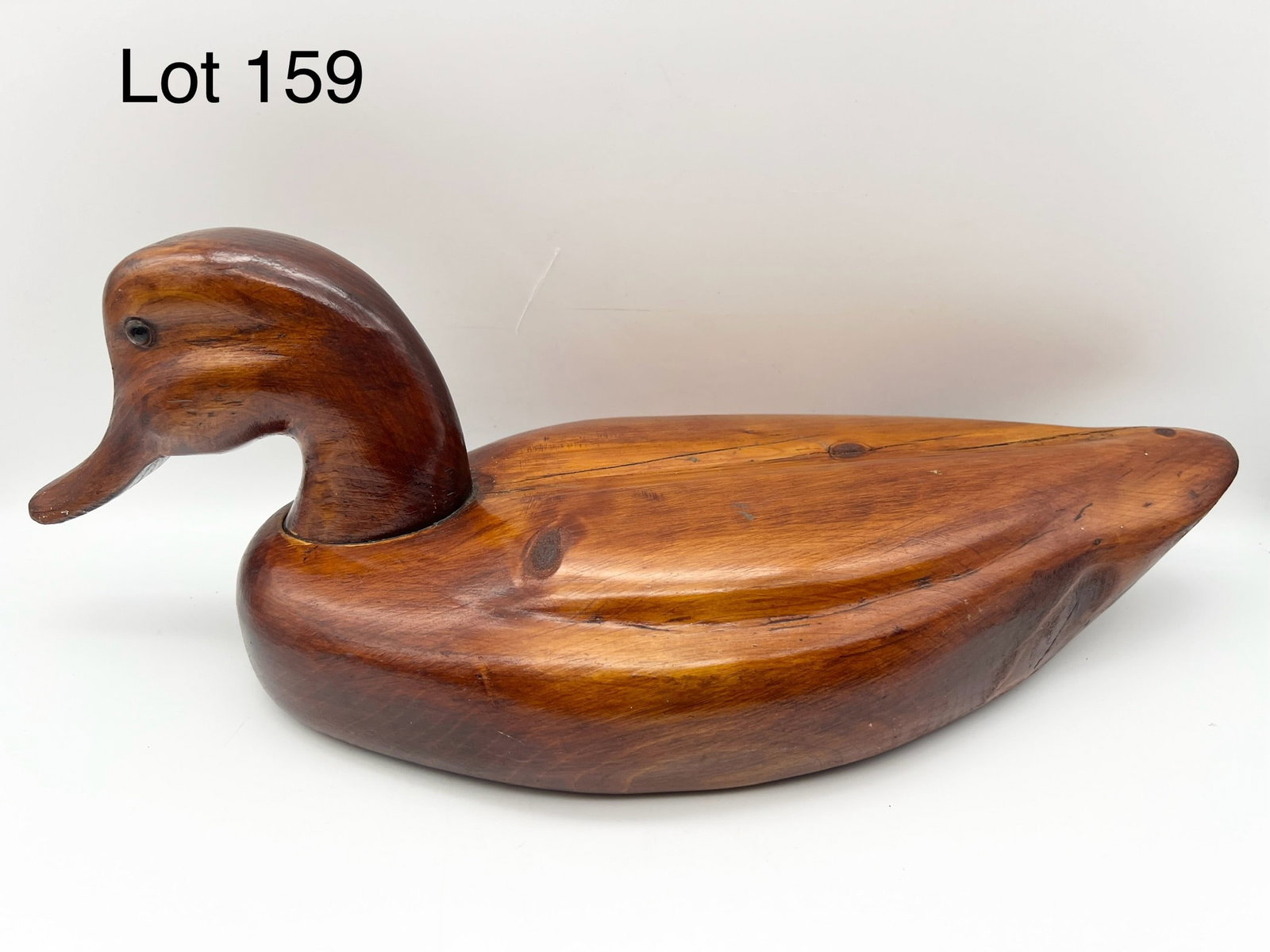 Signed M.G. Schwartz Carved Duck Decoy: A wood carved duck decoy with glass eyes and varnished body. Signed on bottom by M.G. Schwartz in Cecil, NJ. 16 1/2" long. *notes- minor wear, cracks in wood.