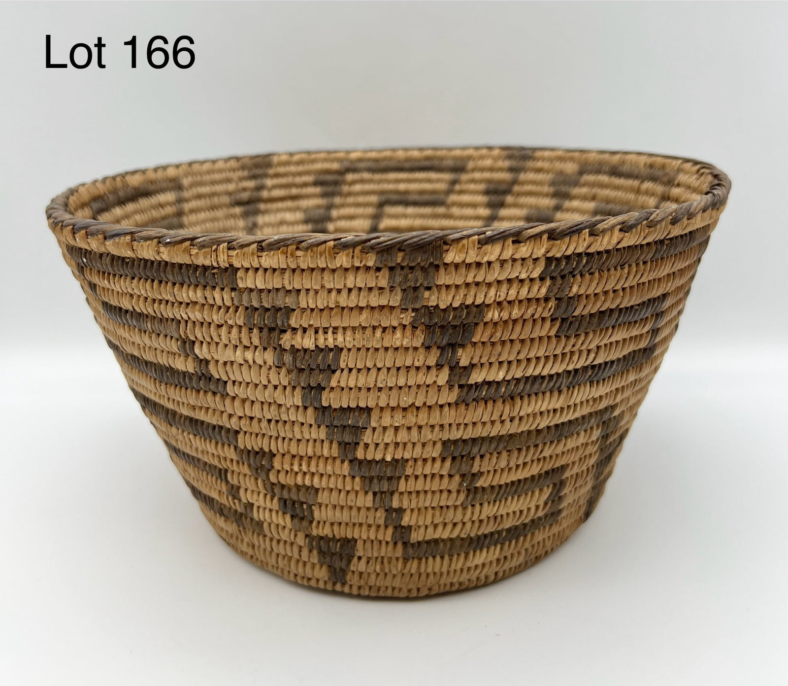 Antique Papago Coiled Basket: A good antique Papago basket woven of split willow and "Devils Claw" bark. A-1 condition. 9 3/4" x 5 1/4".