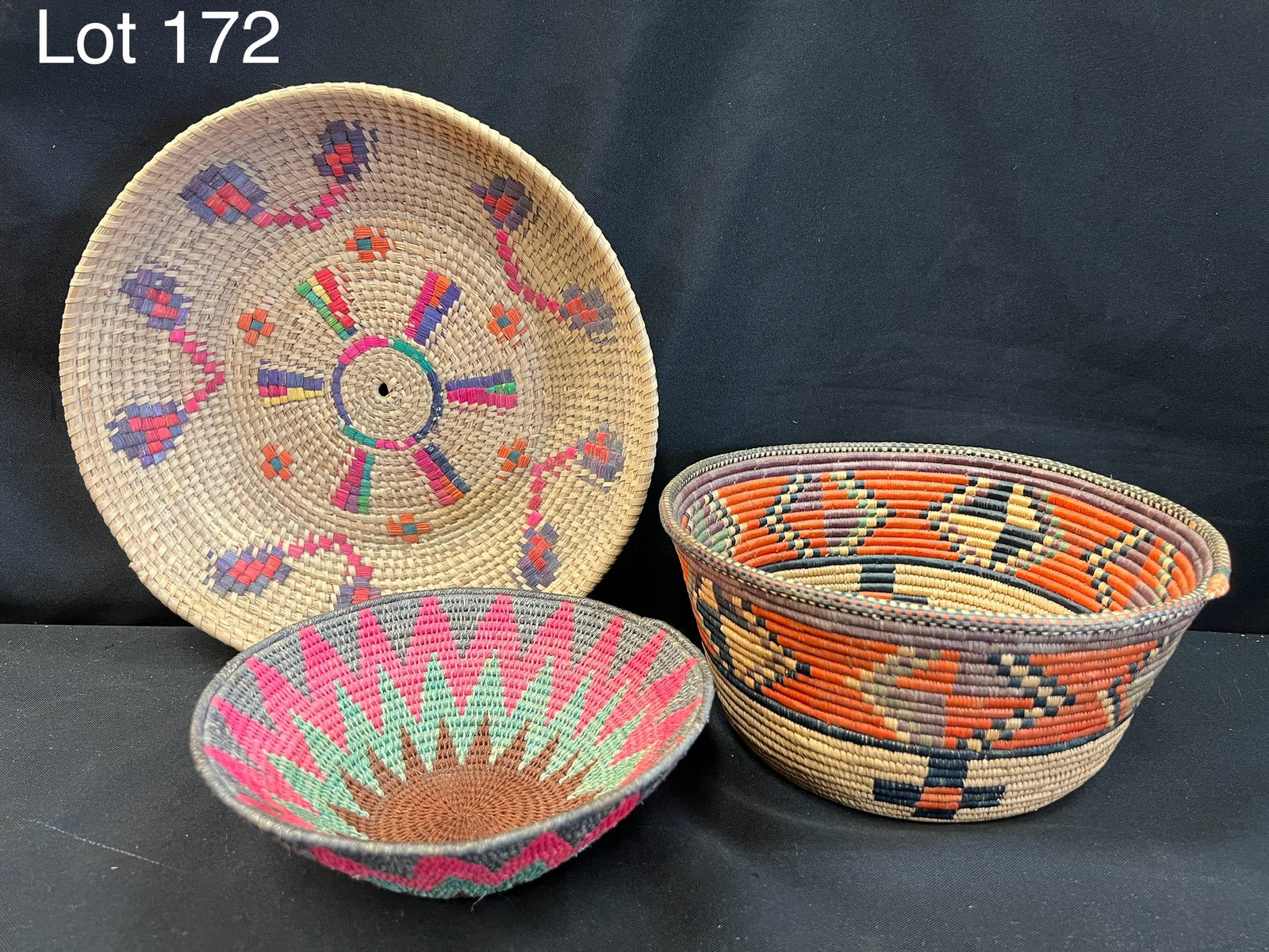 Trio of African Native Coiled Baskets: A group of three African native coiled baskets/bowls with colorful decoration. Largest is 11" diameter.