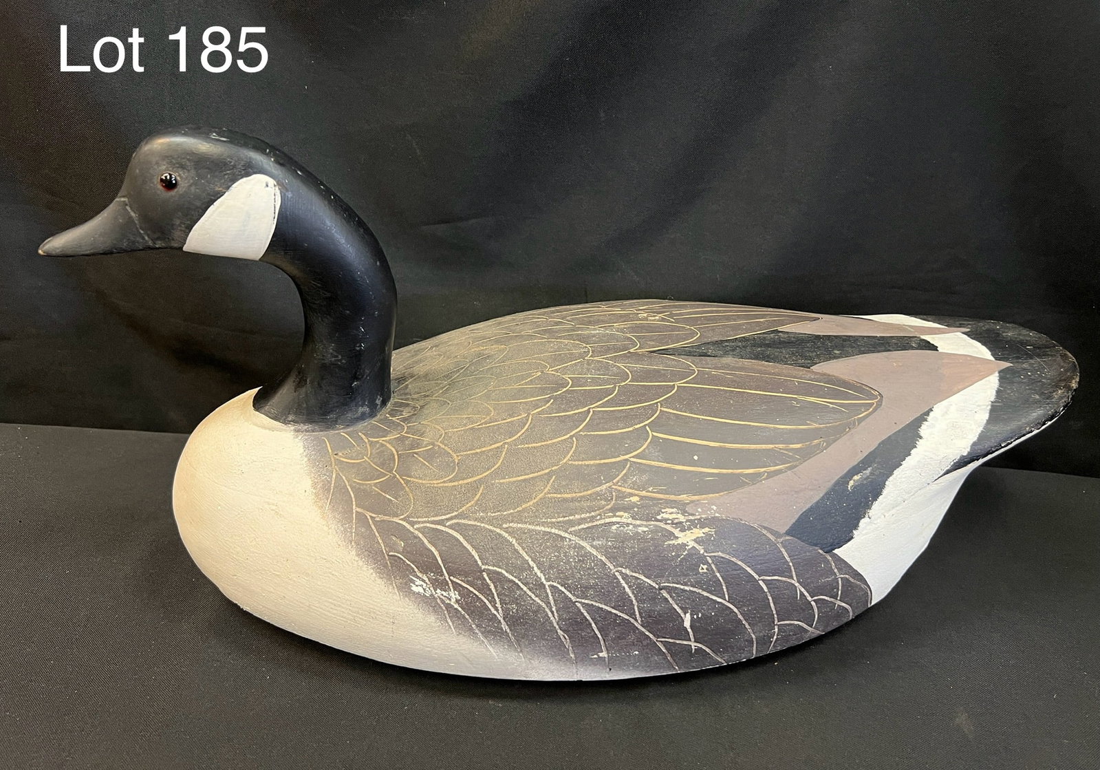 Canada Goose Decoy: A Canada Goose decoy. Glass eyes and hand painted body. Long metal weight attached to the bottom. 21 1/2" long. *notes- wear to paint.
