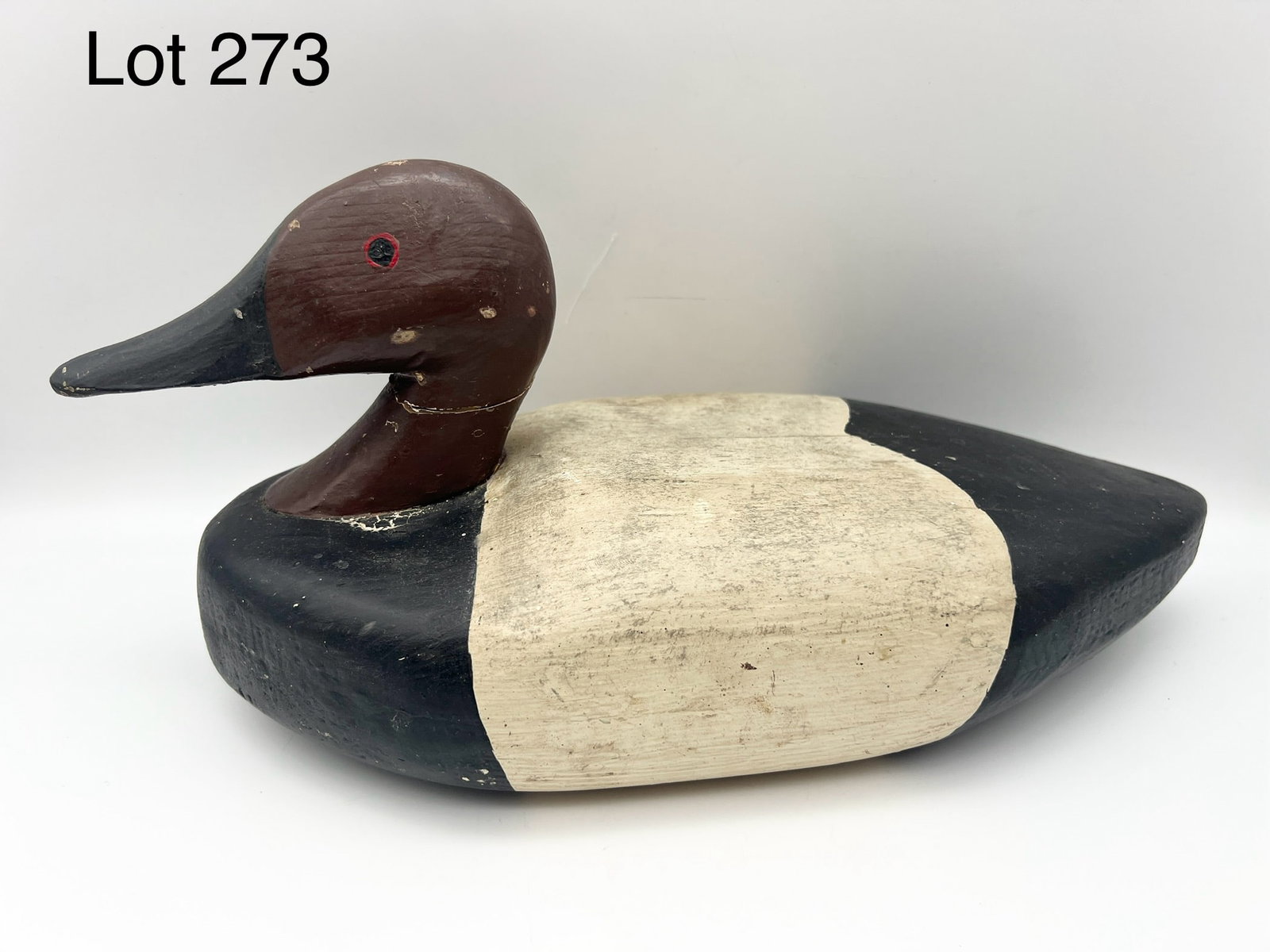 Canvasback Drake Decoy: A carved wood Canvasback drake decoy with painted eyes. 14" long. *notes- wear from age and use, crack at neck