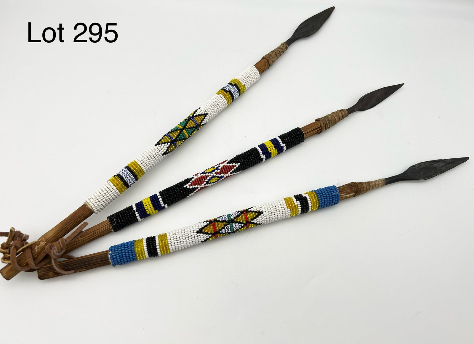 Vintage African Tribal Decorative Spears: A trio of vintage decorative African tribal spears with beadwork motif. All three attached by leather cord. They measure 16" and 15" long. *notes- patina