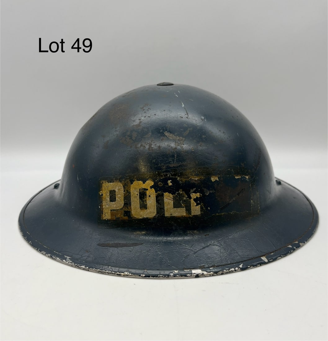 WWII British Police Officer's Steel Helmet: A WWII pressed steel "Brodie" helmet for British police officers. Painted blue, original strap and leather lining in excellent condition. Marked "XL II - HBH 938" on the rim. Measures 12" x 11 1/4" *n