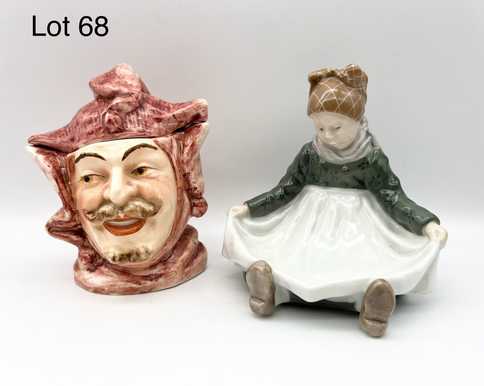 Lot of Vintage Porcelain Decor Including Royal Copenhagen: An antique Majolica jester humidor and a Royal Copenhagen candy dish #1315 in the form of a young girl with apron spread open. Candy dish is 5 1/2" tall.