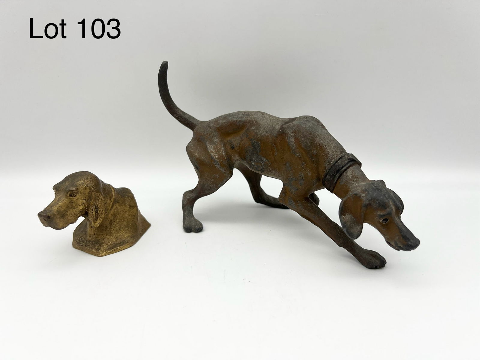 Duo of Dog Figures Including Bronze: A lot of two dog figures. Includes a gilt bronze paperweight of a dog head by Edwin Megargee (1883-1958) titled "Shando" and a cast aluminum hunting hound. Hound is 8" long. *notes- both have wear and