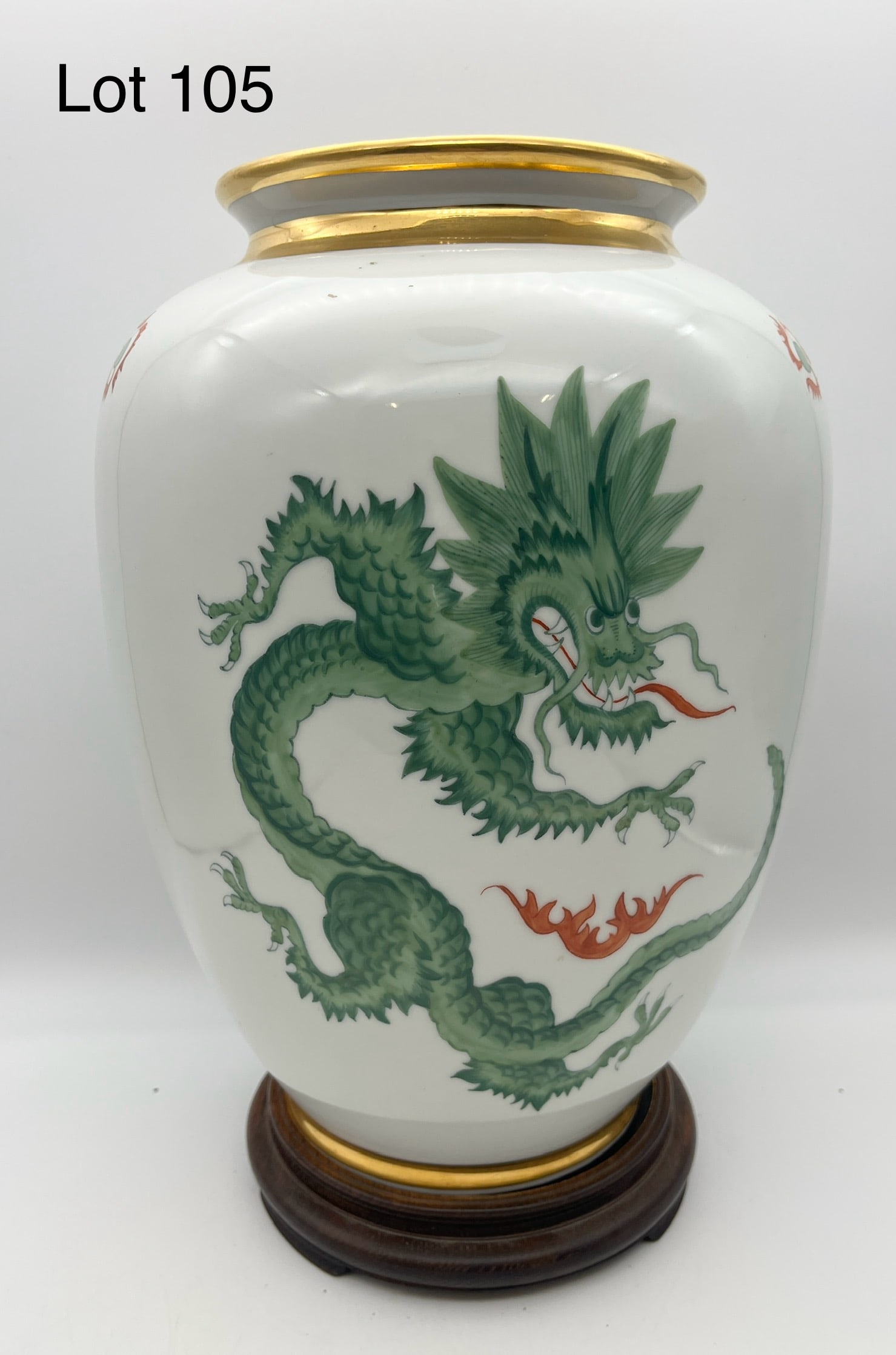 Vintage Meissen Porcelain Dragon Vase: A vintage hand painted Meissen porcelain vase featuring a green Ming dragon on the face with other decorations, gilt painted rim and base. Comes on wooden base, makers marks underneath. Measures 13" t
