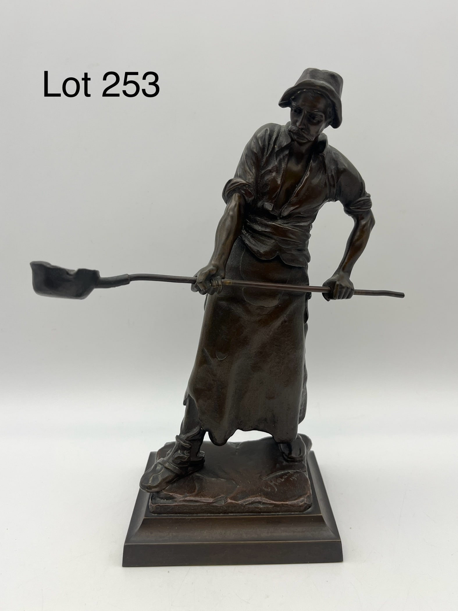 "Foundry Man" Bronze Sculpture by Constantin Holland (19th c.): A bronze sculpture of a foundry worker carrying a ladle of molten metal, signed at the base from Constantin Holland (19th c.) and dated 1900. Finely detailed, measures 9 1/4" tall, 7 1/2" long ladle.