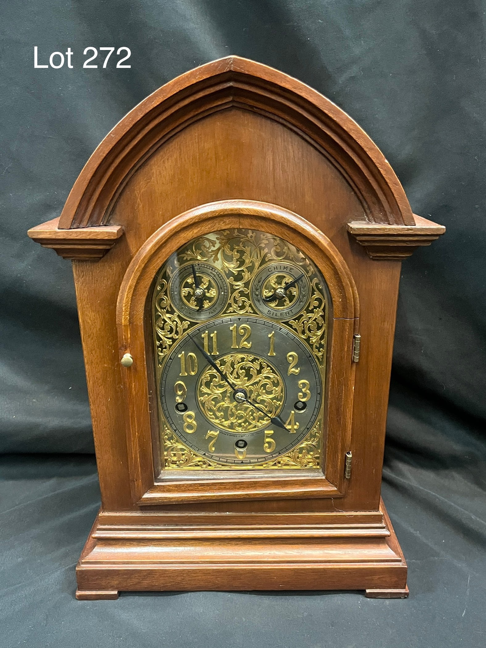 Bailey, Banks and Biddle Bracket Mantel Clock: Bailey, Banks and Biddle bracket mantel clock in walnut case with molded arch pediment over a arched glass door. Clock face is brass and silvered brass with scroll work throughout. Pendulum in back. W