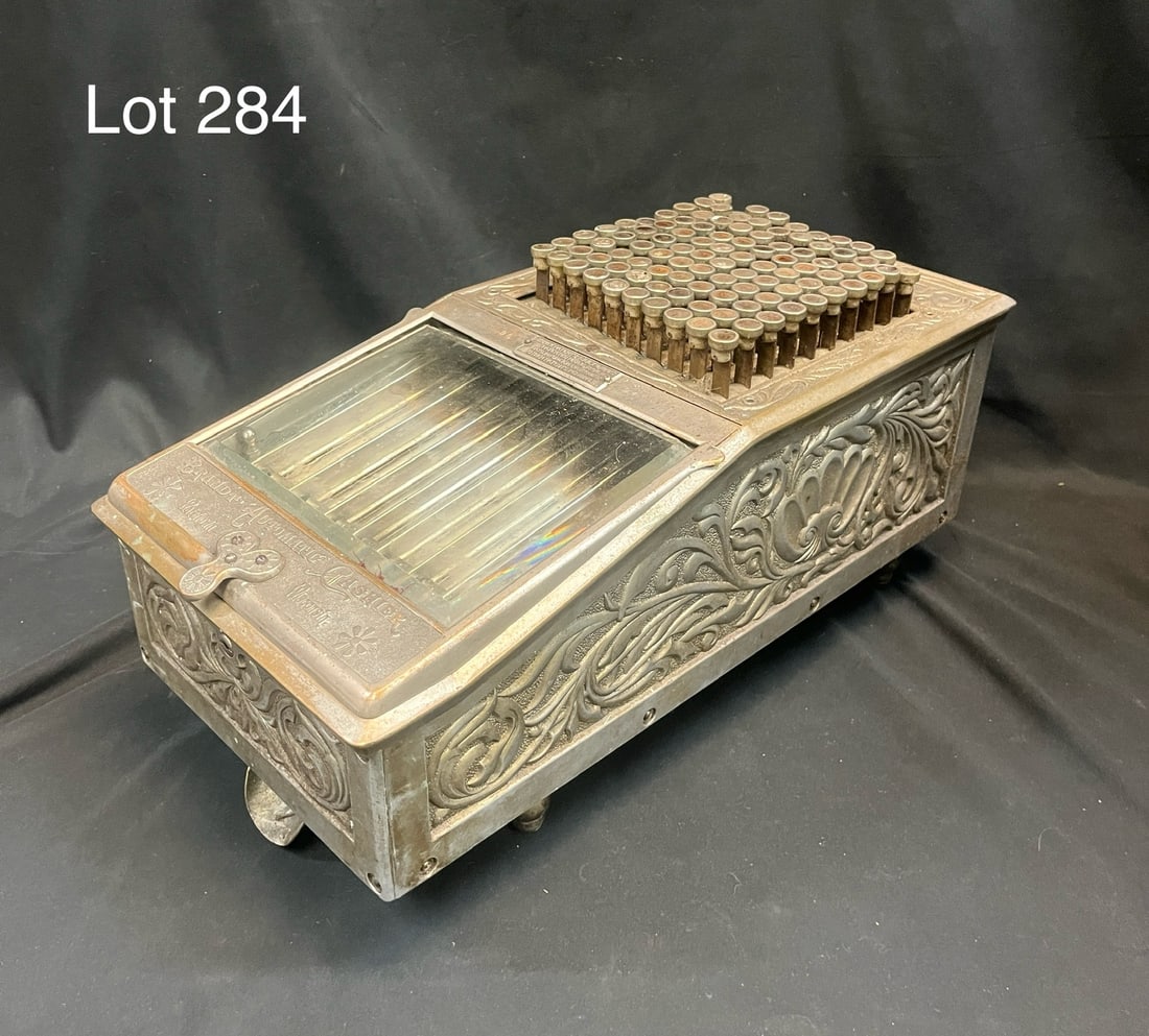 Antique Brandt Automatic Cashier Machine: An antique Brandt Automatic Cashier coin machine. Footed, flowing metal design work around the exterior. Measures 9" x 18" x 8 3/4"
