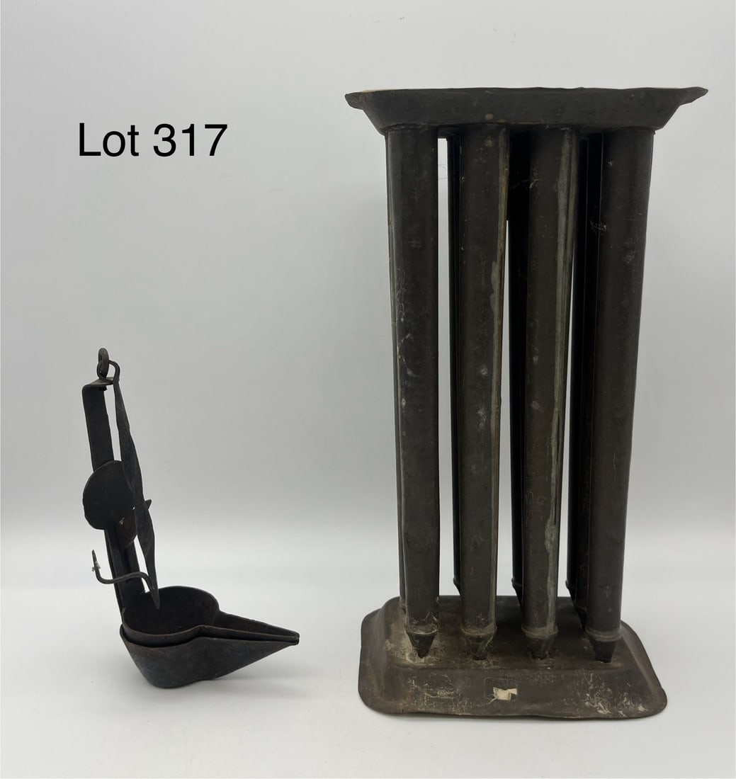 Duo of Cast Metal Primitives: Two cast metal primitives, both in very good condition. Includes a tin twelve candle mold and an antique fat lamp, Candle mold measures 11 1/4" tall. *note - patina