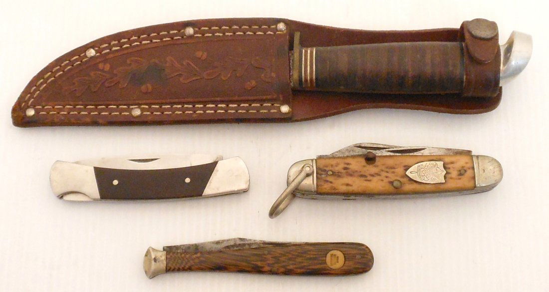 Three Pocket Knives and One Hunting Knife: Lot of four. One baseball bat knife made in Germany. One Boy Scout Knife by Ulster. One Buck knife with a broken off tip. One Western Hunting Knife in a Sheath. All are in good condition with some sig