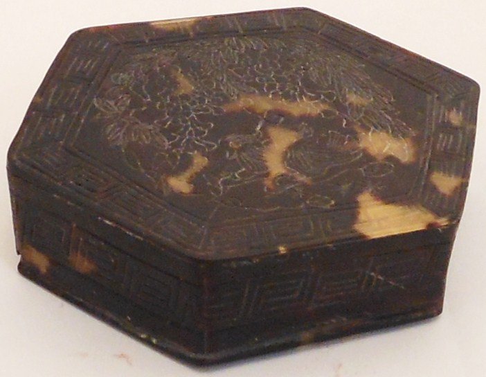 Tortoise Shell Snuff Box: 3" wide X 7/8" tall, China, hexagonal shaped lidded snuff box constructed of tortoise shell, lid is decorated with key fret borders on the sides and top with birds under a cluster of plants and fruit.