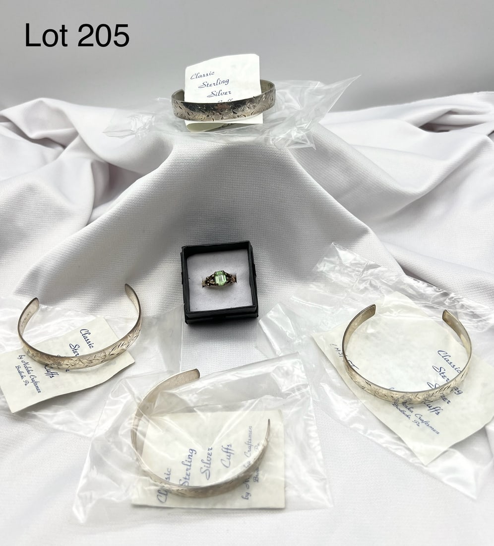 Sterling Silver and Gold Filled Lot: A lot featuring sterling silver and gold filled jewelry. Includes a 10K gold filled ring with green stone (size 7), a gold filled National Honor Society pin and four sterling silver cuff bracelets by