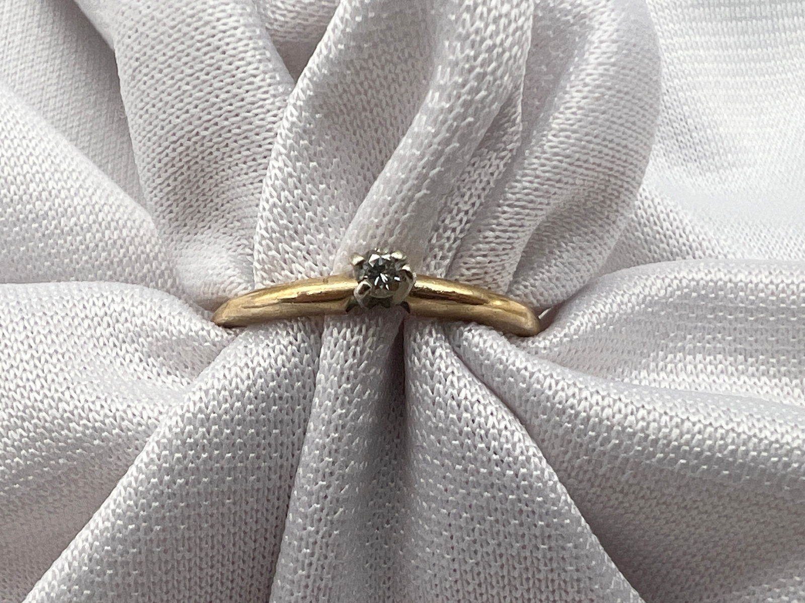 14K Gold Diamond Ring: 14K yellow gold ring with round cut diamond solitaire. 0.95 dwt. Size 7.75.