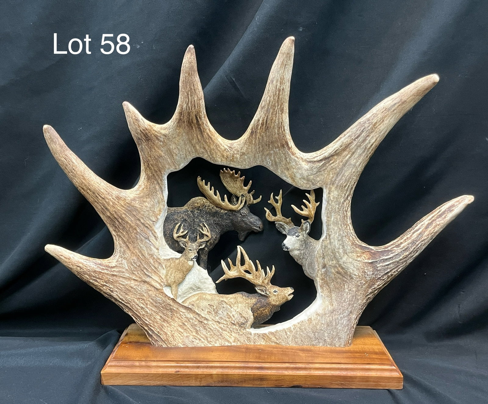 Carved Moose Antler Display: A hand carved section of a moose antler with painted figures of North American deer, elk, and moose. Detailed, openwork construction showing each animal with remarkable realism. Mounted on wood base, 