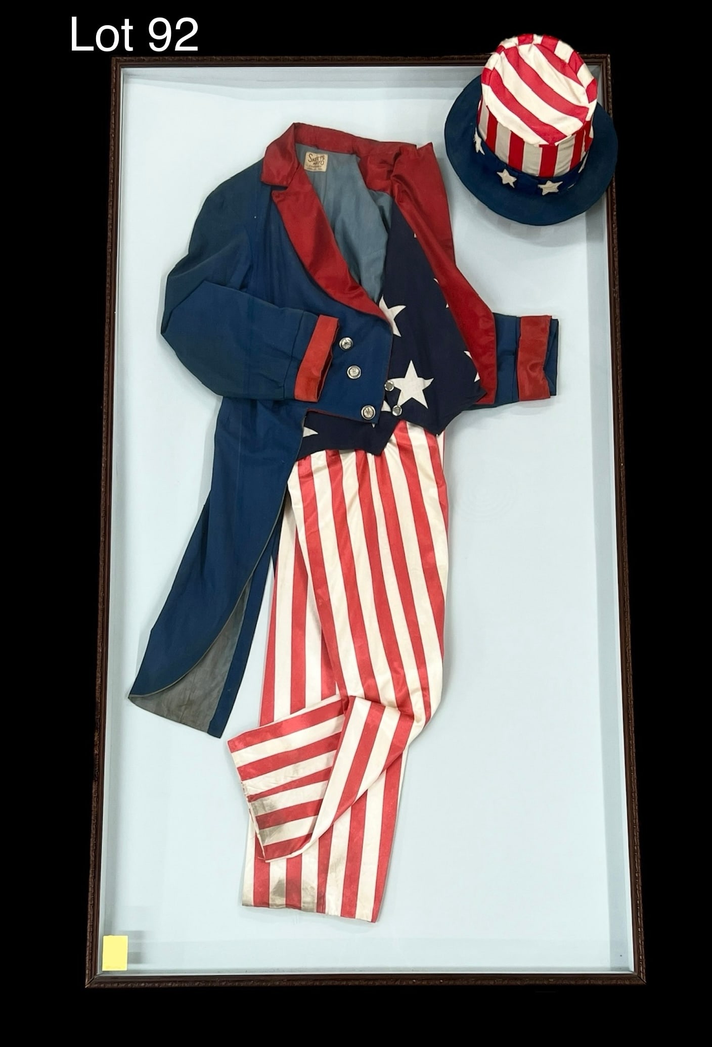 1930s Uncle Sam Parade Costume: A 1930s Uncle Sam parade costume presented in large showcase frame. Includes top hat. Sold by Skeets Mayo Costumes, Nashville, Tennessee. Frame is 61 1/2" x 33 1/2". **PICK UP ONLY**