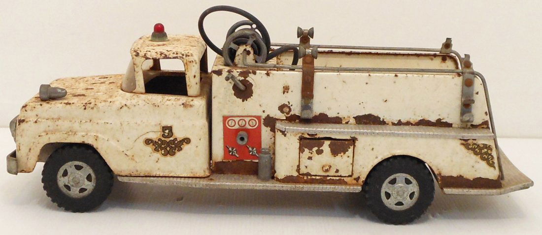 Vintage Tonka #5 Pumper Fire Truck in White.: 1956 Tonka Pumper Fire Truck with wind up rubber hose, missing ladders, side compartment door and hydrant. Good condition with paint loss and rust, rear deck is bent.