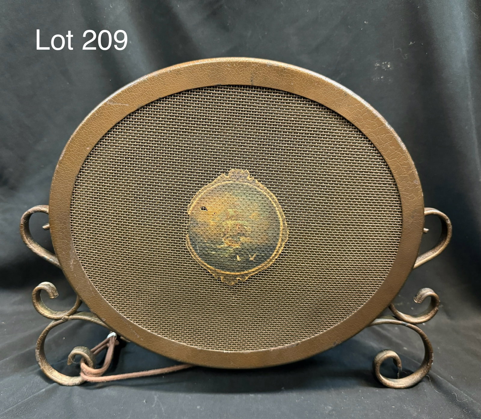 Antique Art Deco Radio Speaker: An antique art deco radio speaker. Oval shape, curled metal legs, faint imagery of a sailing ship on the front.