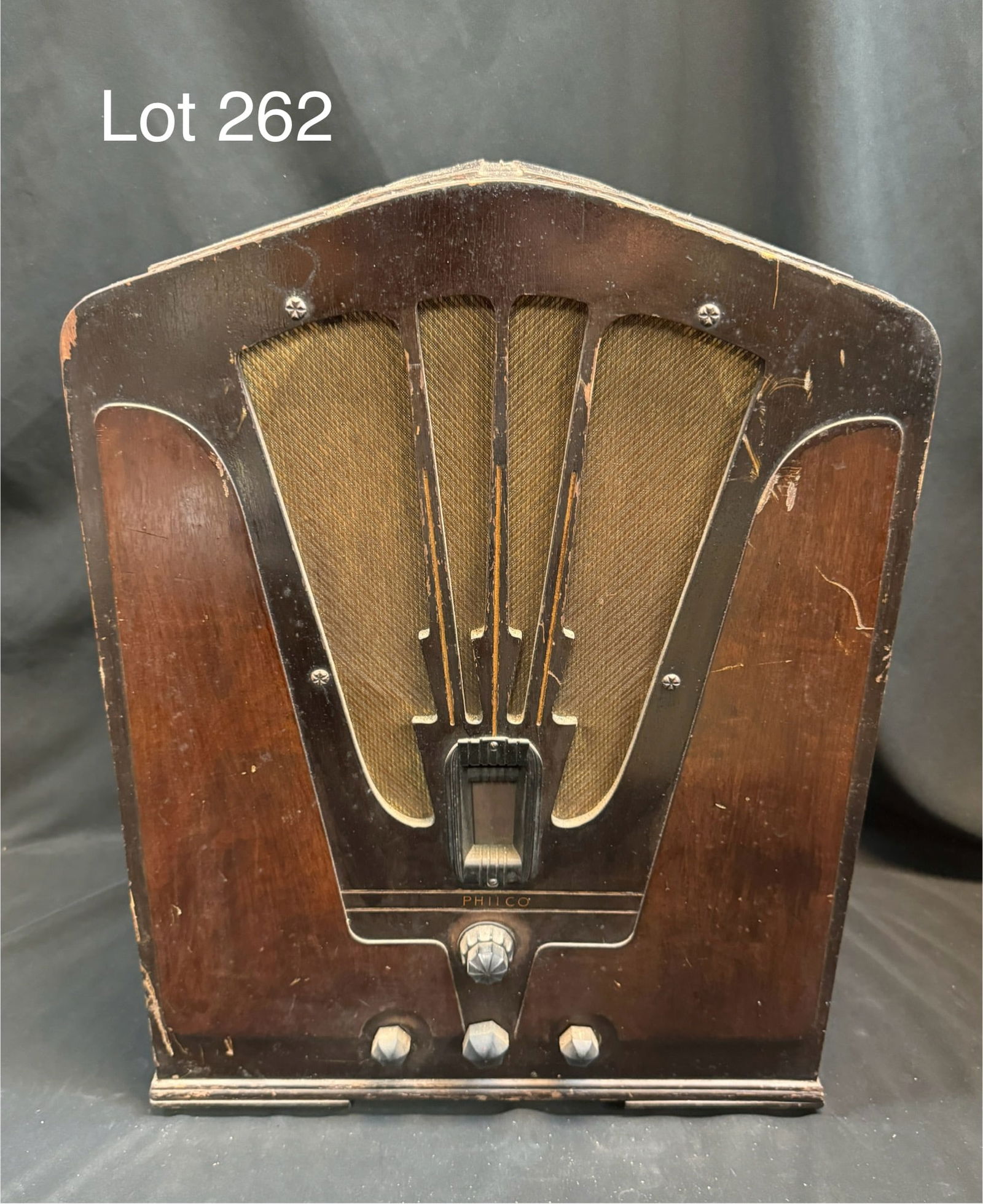 Philco Model 16B Tube Tombstone Radio: A 1930s Philco model 16B tube tombstone radio. Two tone wood case, fan-like cut out cloth grille, window dial w/ 4 knobs. Piece shows wear, corrosion, and residue. Comes with extra Sylvania tube.