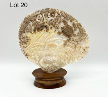 Carved Marine Shell: A delicately carved marine shell with sea turtle and undersea plant motifs. Stands on wood base. Shell dimensions are 4 1/2" x 5 1/2".