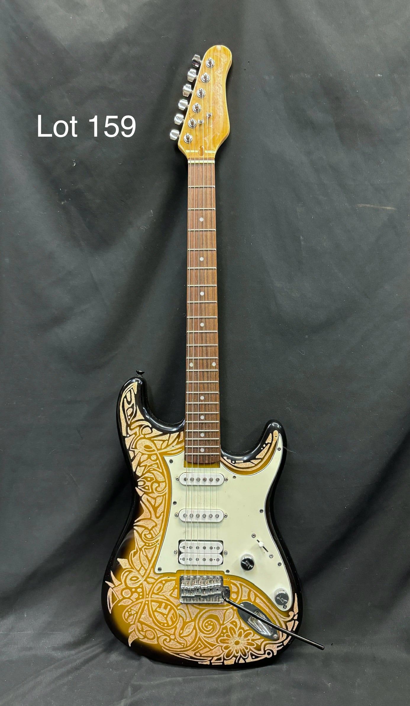 Hand Carved Electric Guitar: A vintage electric guitar with hand carved design work throughout the front of the body and head. No makers marks noted. Measures 39" long. Comes with case