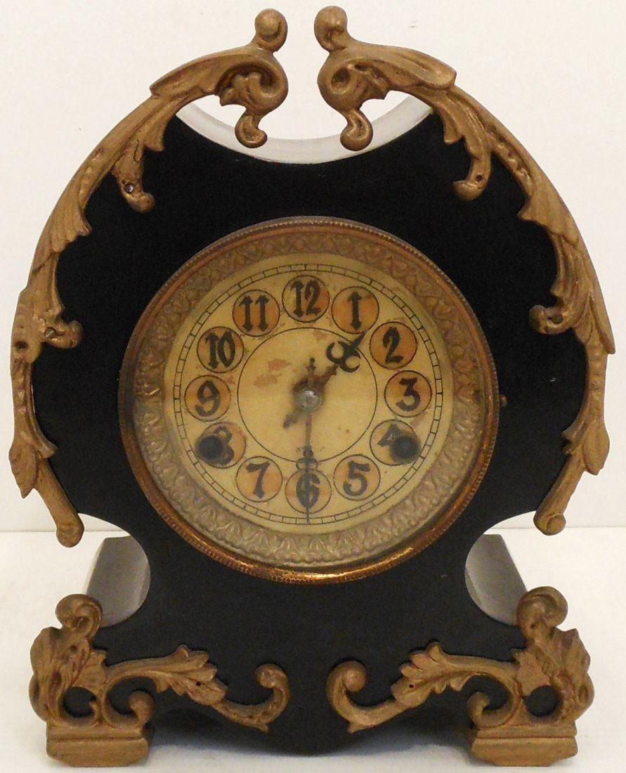 New Haven Parlor Clock: 12" tall X 9" wide X 5 1/4" deep, Ornate New Haven Parlor Clock, time and strike, heavy metal case with gold colored trim, face has some loss, good physical condition includes pendulum, with minor adj