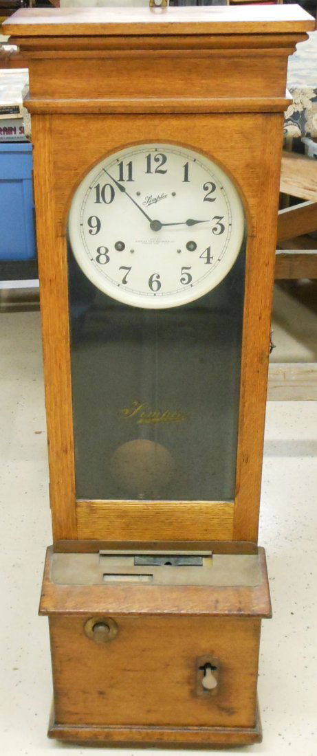 Simplex Time Clock: 48" tall X 15" wide X 11" deep, A Simplex Time Clock. Dial signed 'Simplex Time Recorder Co., Gardner, Mass'. Circa 1920's, original glass has company logo, oak cased clock with a flat cornice top. Ba