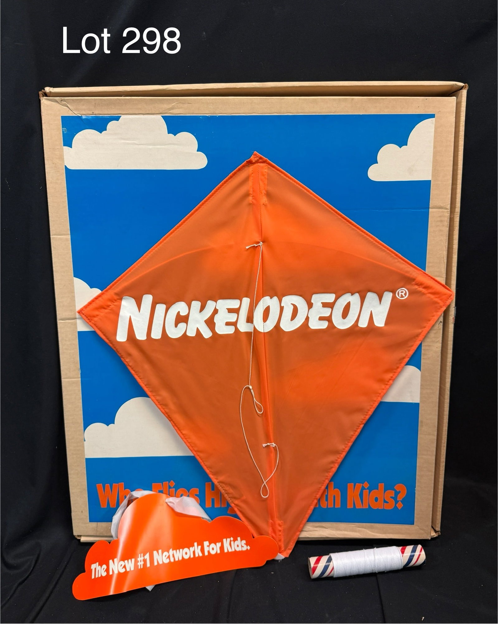 Nickelodeon Promotional Kite Press Kit: A Nickelodeon press kit with a branded orange kite in a box labeled 'Who Flies Highest With Kids?' Marketing information on the kite's tail, box measures 22 1/2" x 26 3/4"